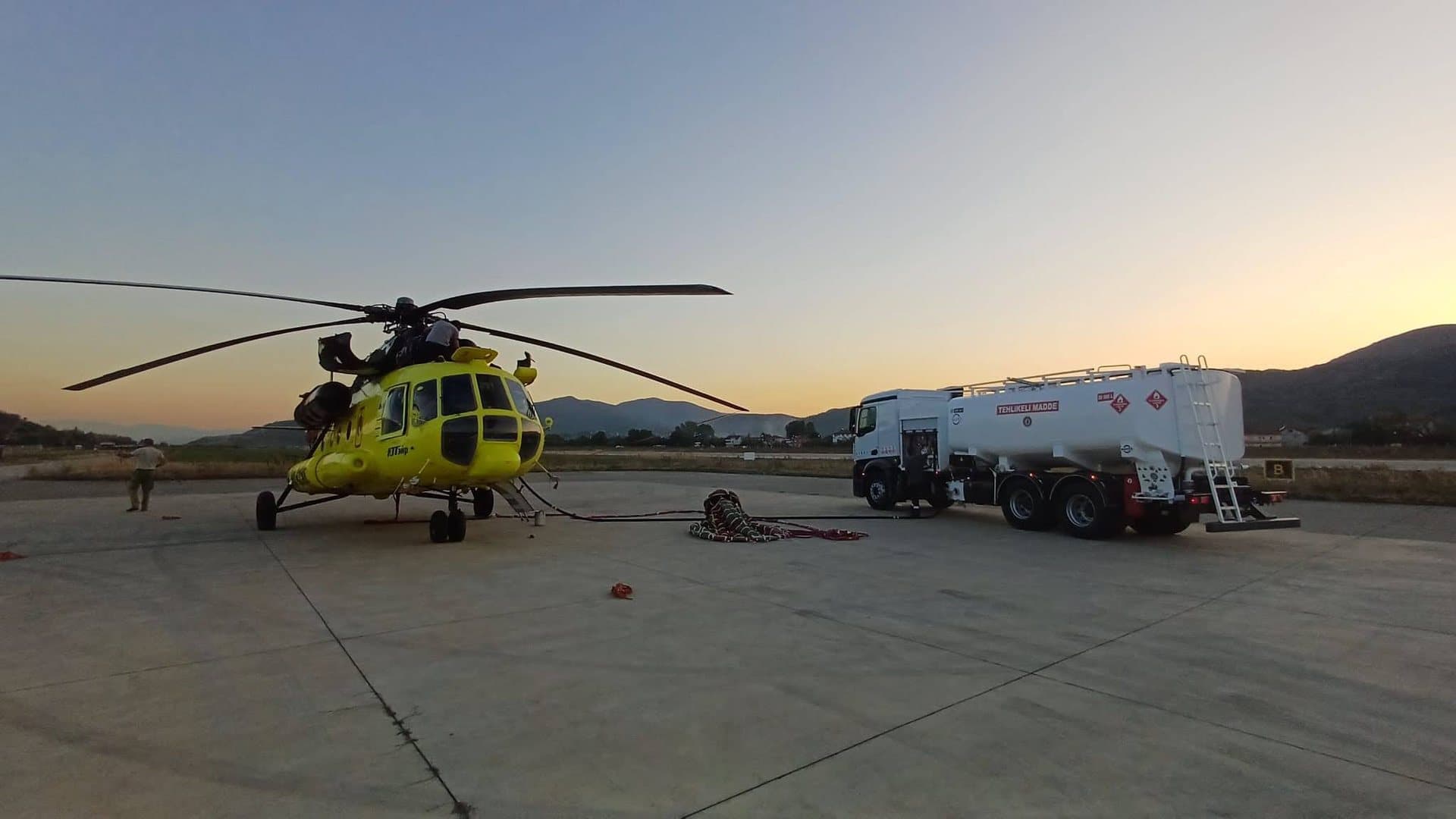 MATEŞ rigid refueller beside a Mi-8 helicopter at dusk